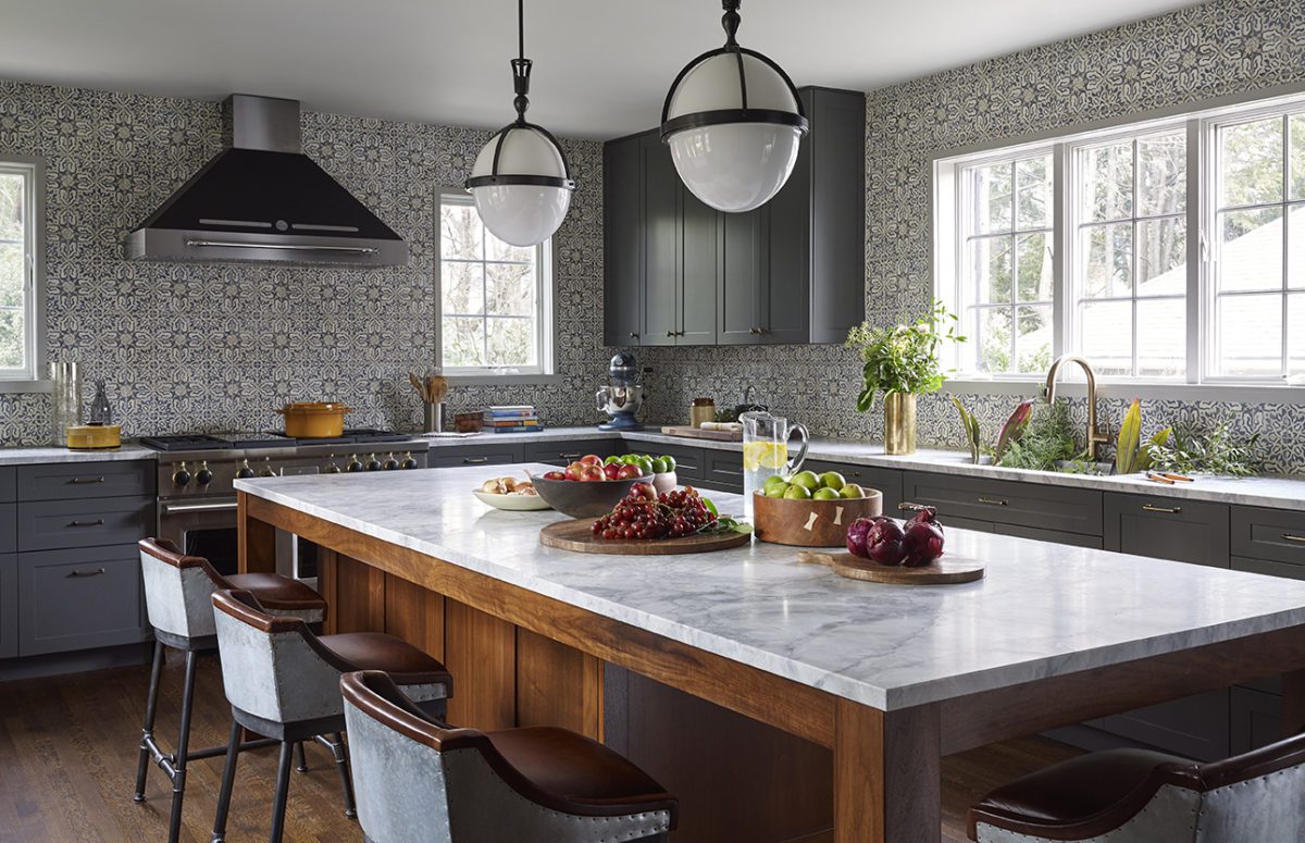 Larchmont House | Kitchen in Grey and White Tones With A Big Dining Table In the Middle Filled with Fruits
