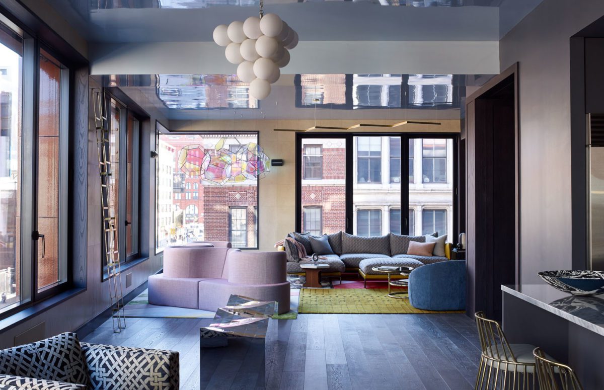 A Living Room with a Blue and Purple Interior Design and Big Windows with Views of the Buildings