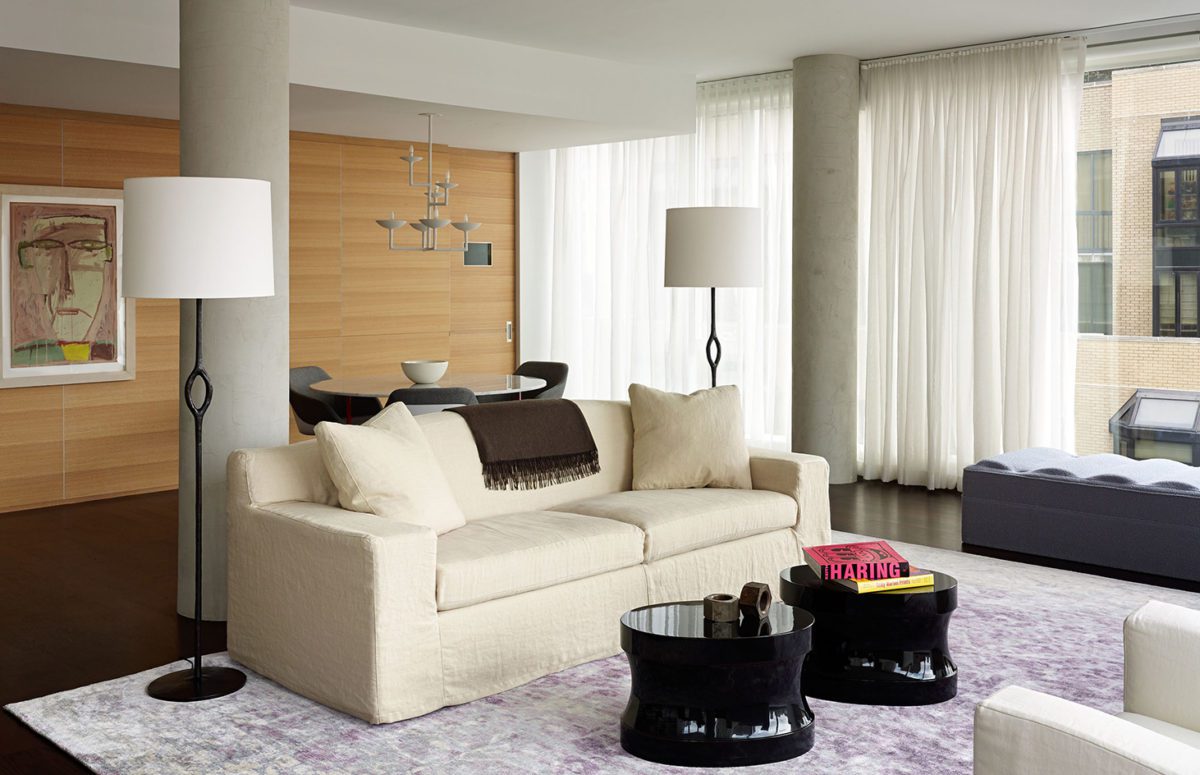 Spacious Living Room with White Tux Sofa and Armchairs and Two Black Round Tables