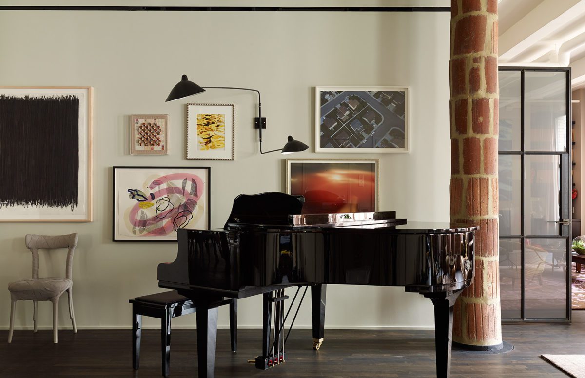 Dark Brown Royal Piano and A Wall with Multiple Paintings in Different Sizes