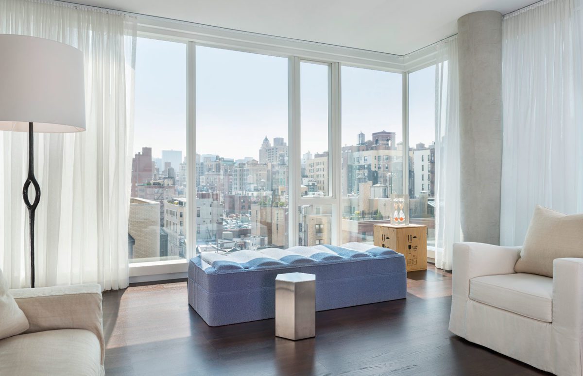 Light Blue Bench next to A Big Window with Views of the City