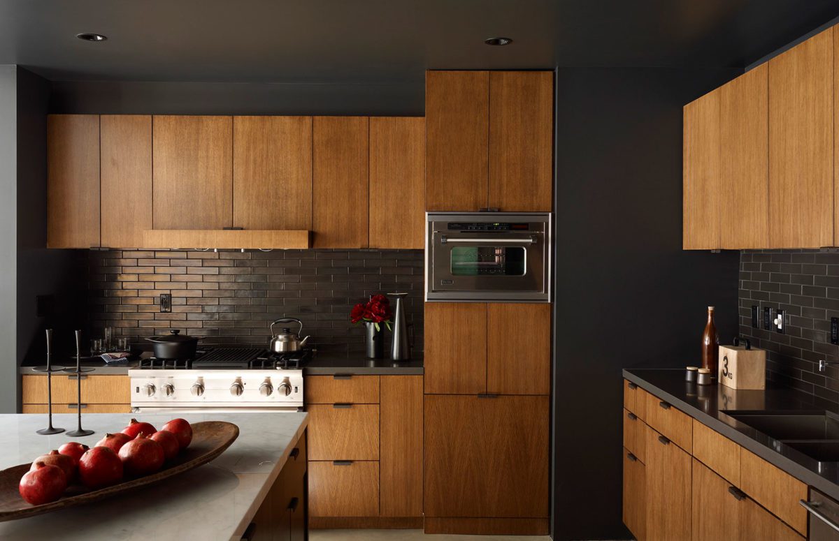 Kitchen Cupboard in Amber Wood Color and a big table in the middle.