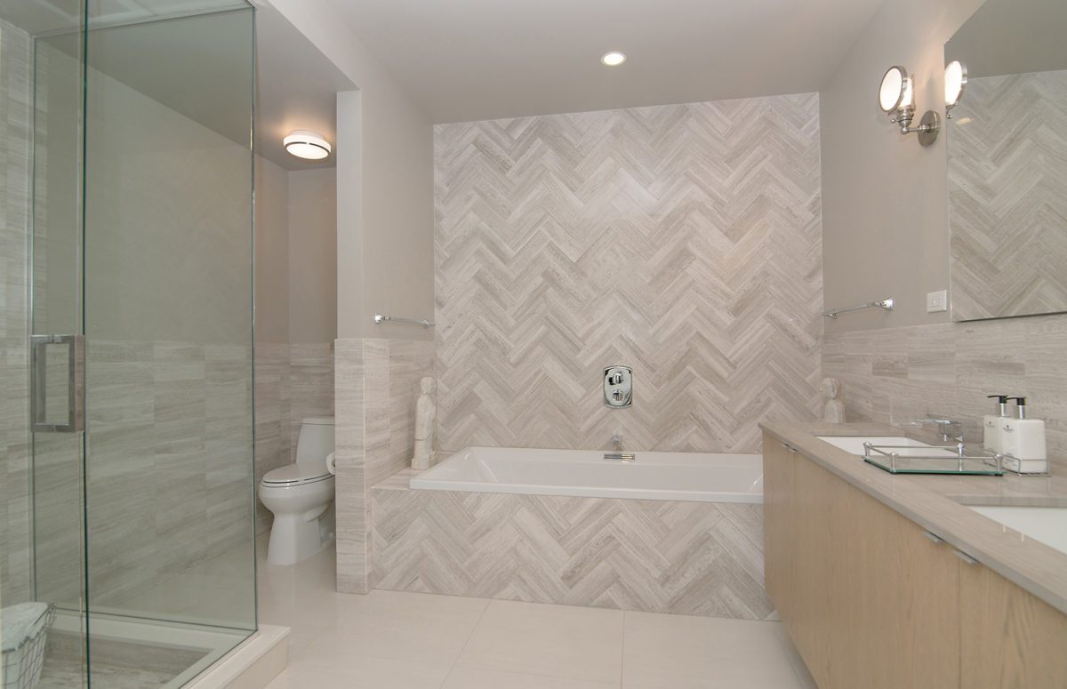 Spacious Bathroom with White Interior Design, a bathtub, two sinks with cabinet and a toilet.