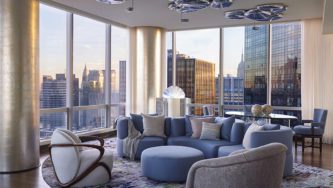 ONE57 Apartment | Livingroom of blue hues and view of the NYC skyline