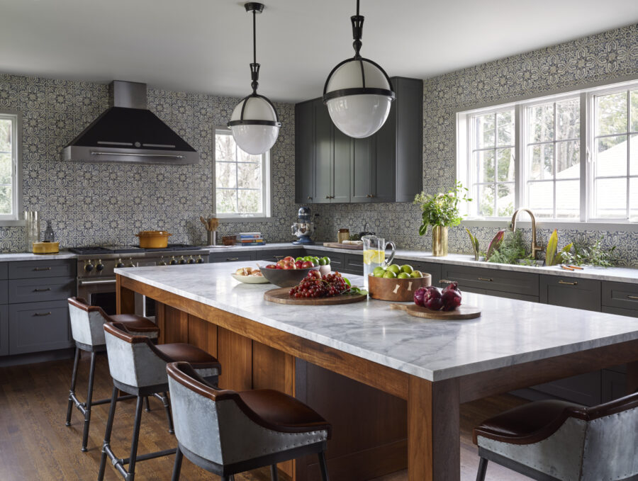 Larchmont House | Kitchen in Grey and White Tones With A Big Dining Table In the Middle Stuffed With Fruits