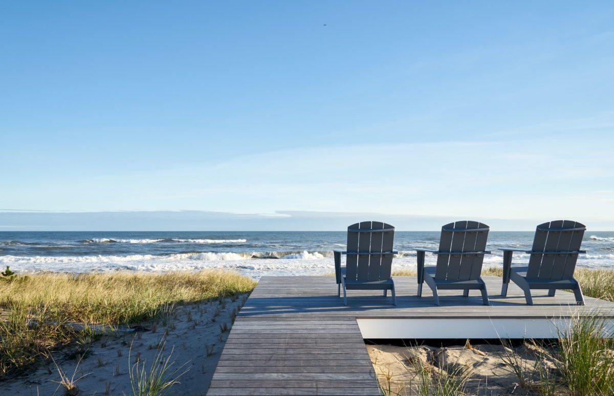 Outdoor seating by the beach with wooden chairs and deck