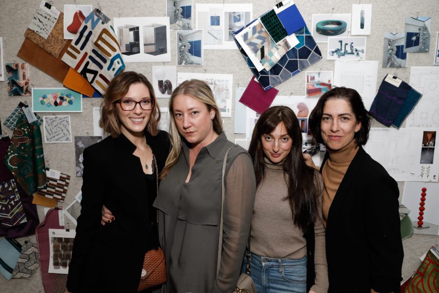 Four people posing in front of Bulletin in Showroom