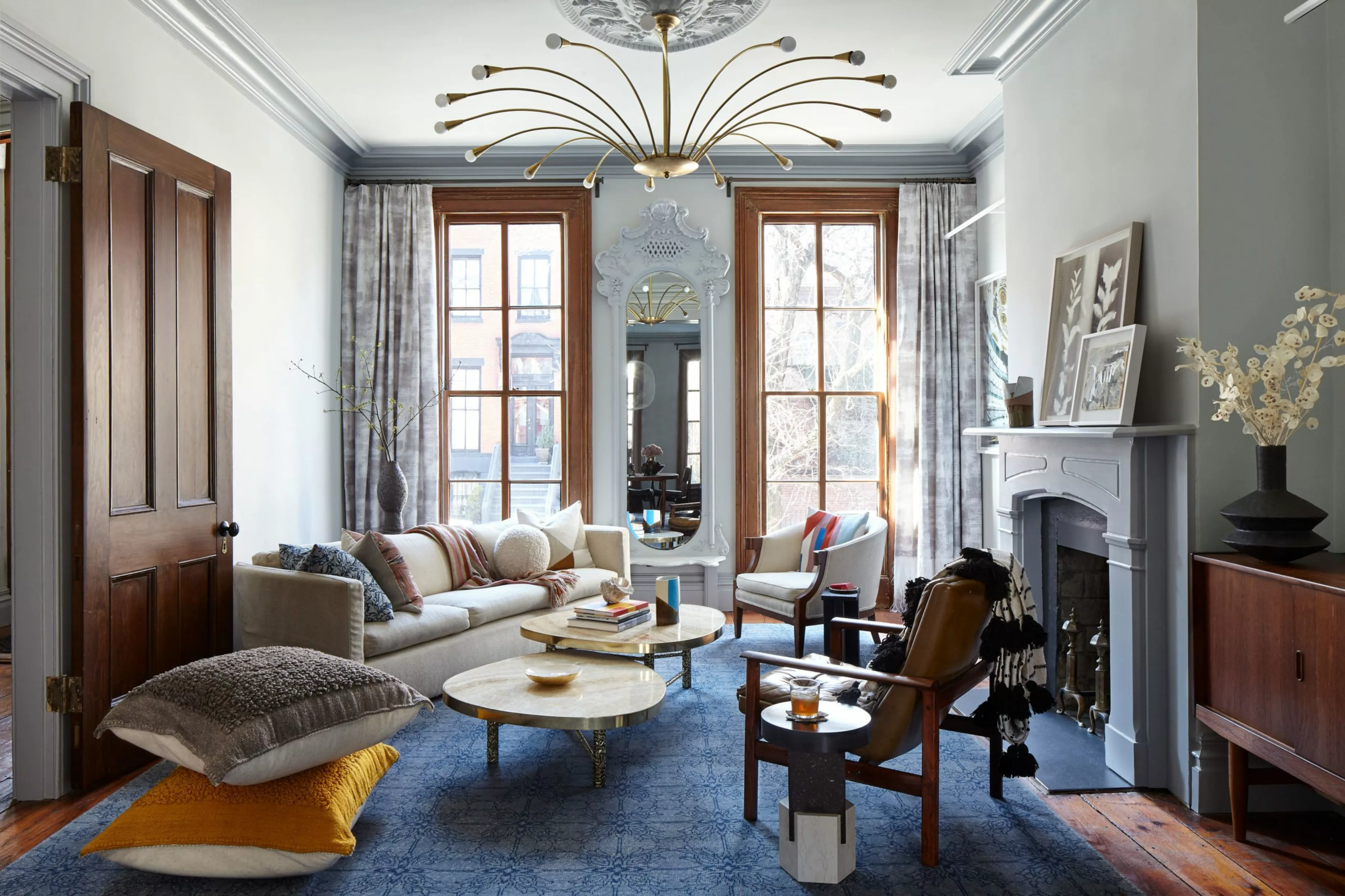 Brooklyn Townhouse | Living Room with White Cozy Sofa and Two Wooden Chairs next to the Fireplace