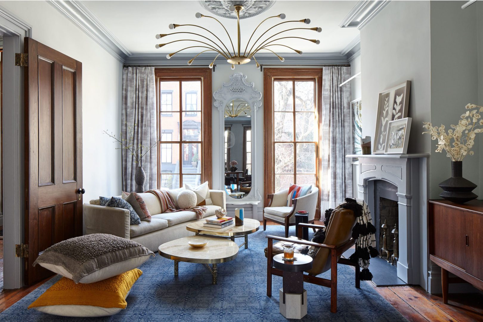 Brooklyn Townhouse | Living Room with White Cozy Sofa and Two Wooden Chairs next to the Fireplace