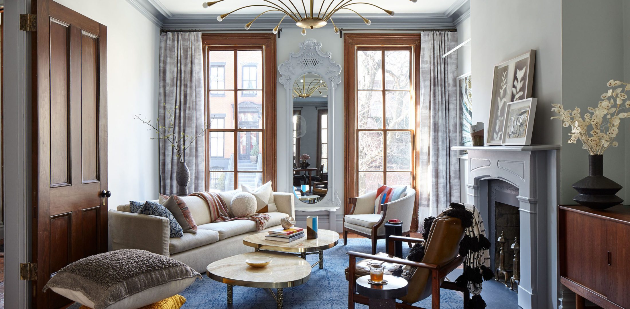 Brooklyn Townhouse | Living Room with White Cozy Sofa and Two Wooden Chairs next to the Fireplace