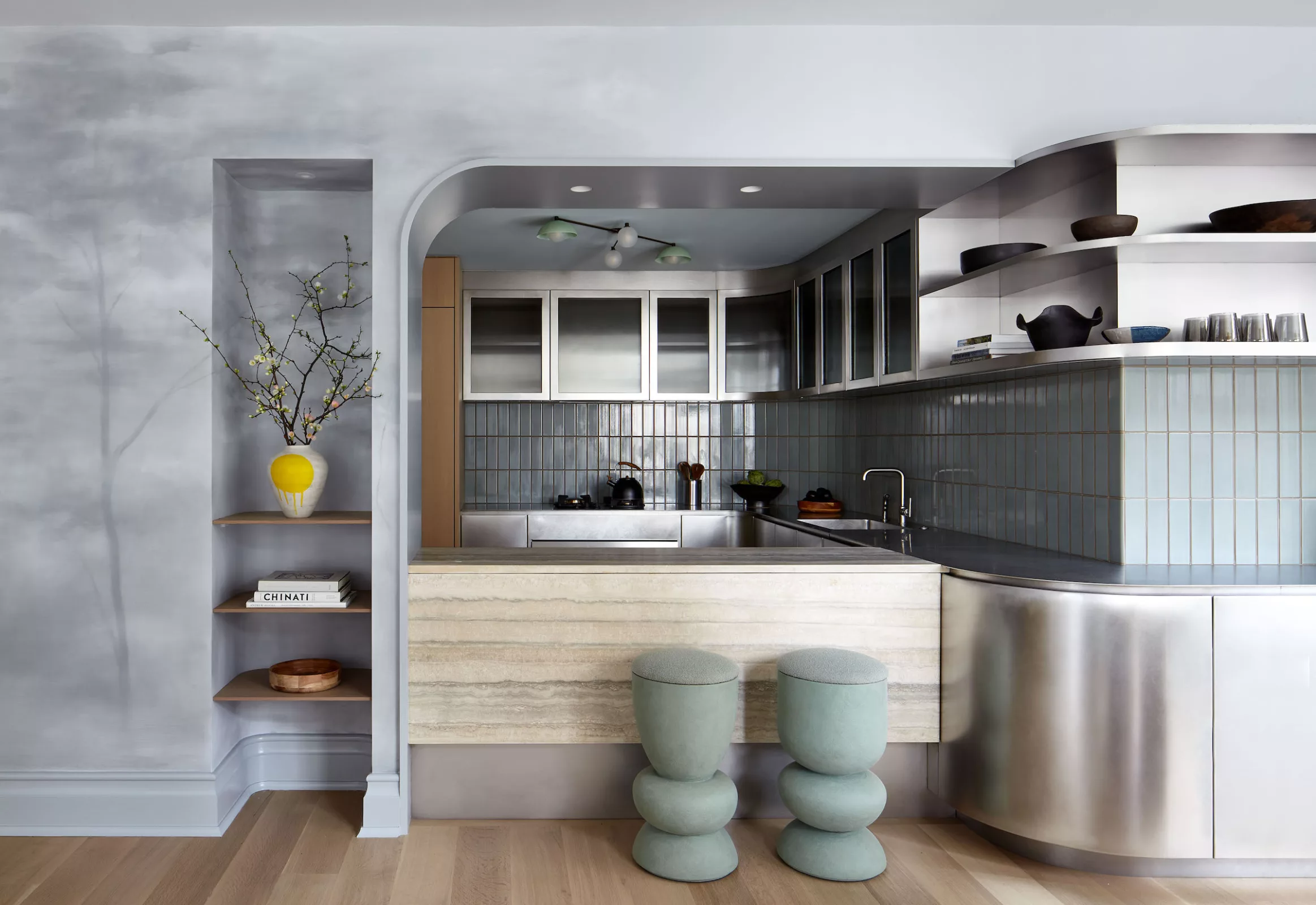 Modern steel kitchen with travertine counter and custom painted mural wall