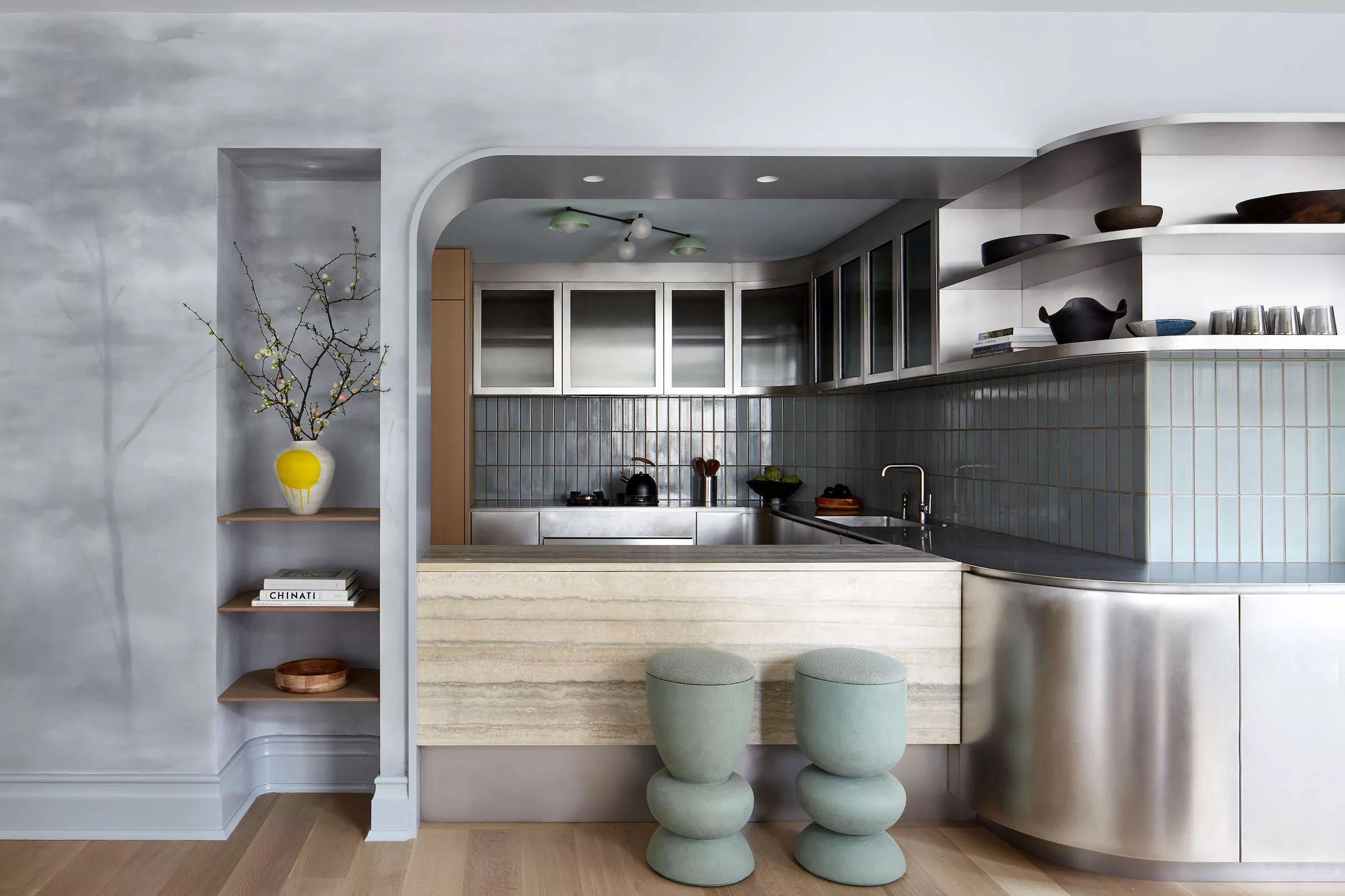 Modern steel kitchen with travertine counter and custom painted mural wall