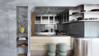 Modern steel kitchen with travertine counter and custom painted mural wall