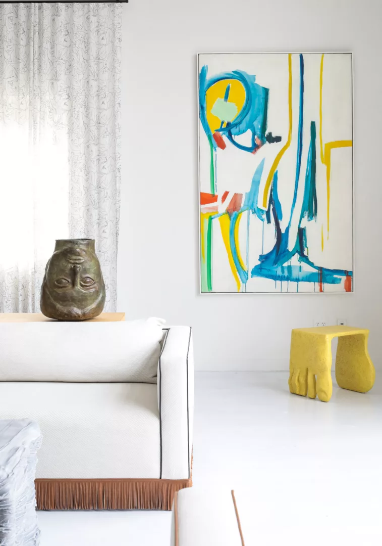 Gallery view with colorful abstract painting and white sofa