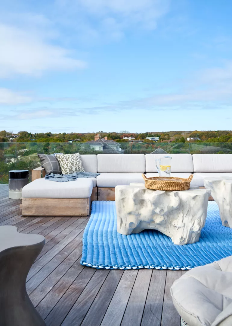 outdoor rooftop design with neutral organic forms and ombre blue area rug