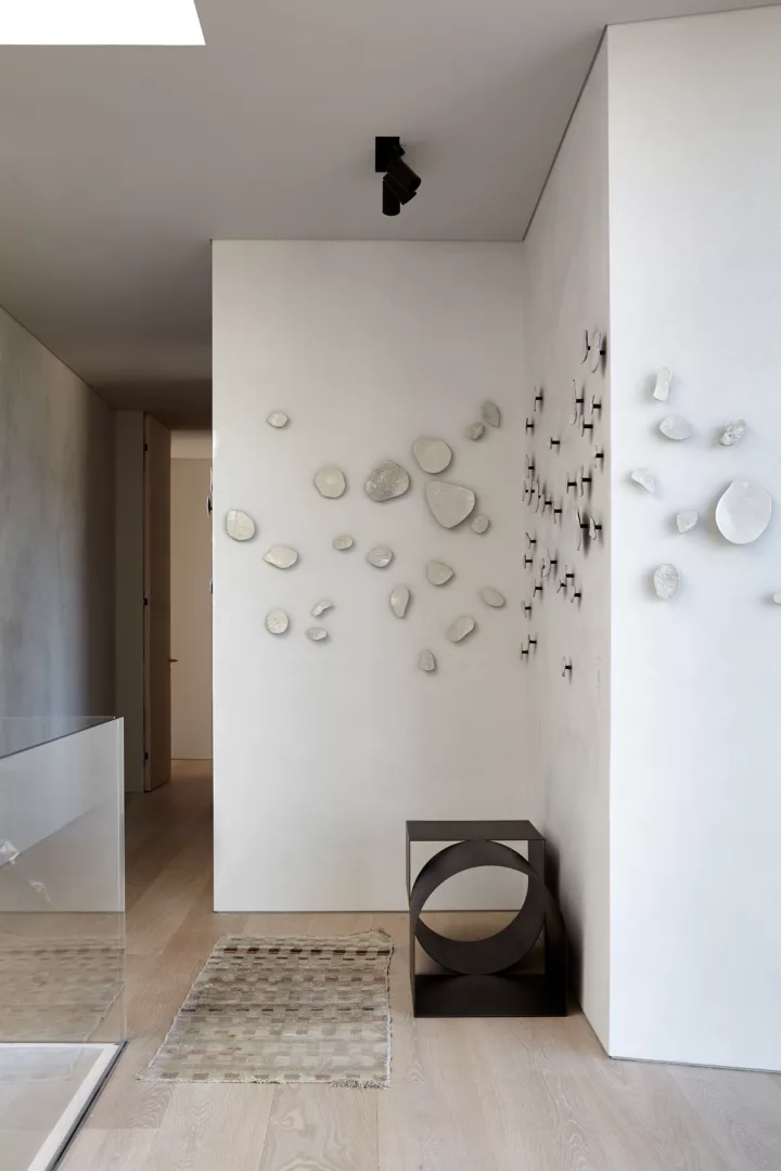 An installation of raku wall sculptures adds artful texture and interest to the overall quietude of the upstairs hallway